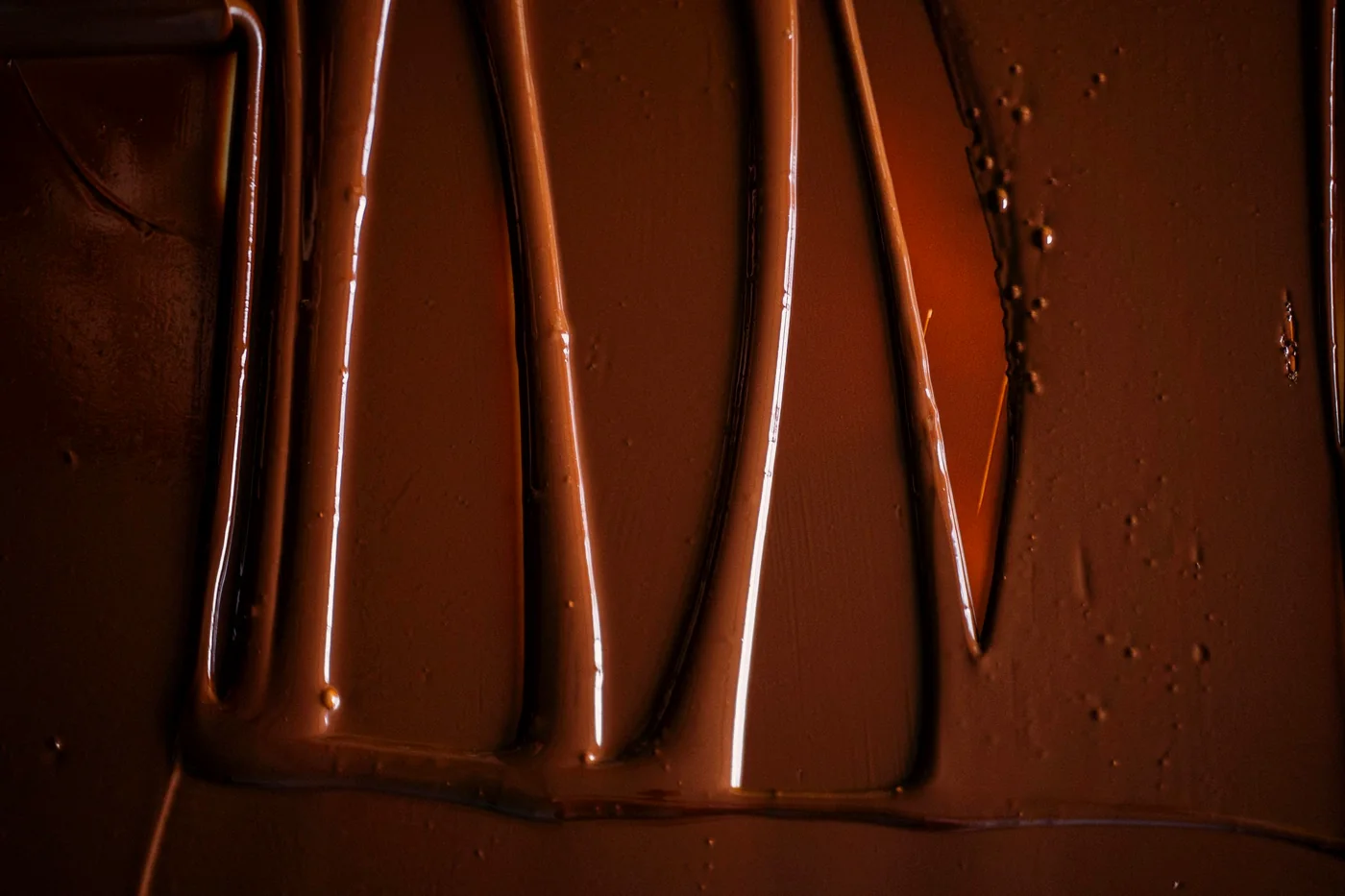 Chocolate temperado escorrendo sobre a bancada