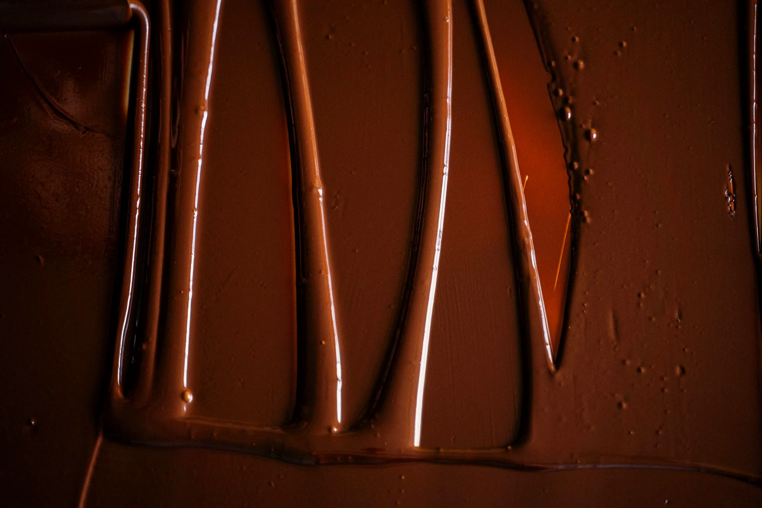 Chocolate temperado escorrendo sobre a bancada